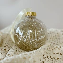 Kerstbal doorzichtig/goud  met naam (witte letters)